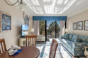 Relaxing Oceanfront Condo - Holiday Pavilion 211 في ميرتل بيتش: غرفة معيشة بها أريكة وطاولة