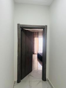 Eine Holztür führt in ein Zimmer mit einem Sofa in der Unterkunft Splendid Apartments in Banjul