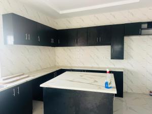 Eine Küche mit schwarzen Schränken und einer Zahnbürste auf der Arbeitsplatte in der Unterkunft Splendid Apartments in Banjul + 11 Fotos