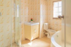 a bathroom with a toilet and a sink and a shower at Comfort B&B in Bulawayo +42 photos