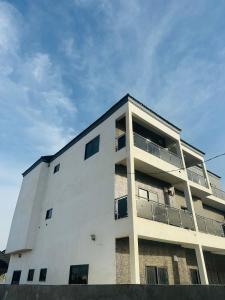 ein weißes Gebäude mit Balkonen an der Seite in der Unterkunft Splendid Apartments in Banjul