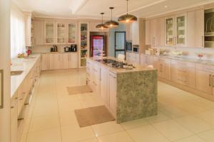 a large kitchen with white cabinets and a large island at Comfort B&B in Bulawayo