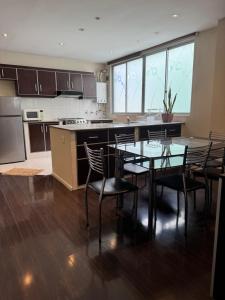 a kitchen with a table and chairs in a room at 7th floor Live, Laugh and Relax in Cochabamba