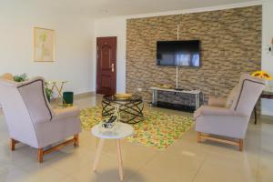 a living room with two chairs and a tv at Comfort B&B in Bulawayo