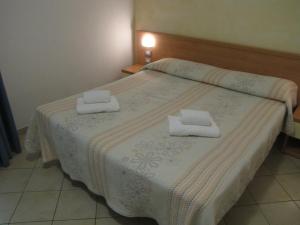 Residence Rosemary في برنزوني سول جاردا: غرفة نوم بها سرير عليه منشفتان