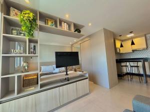 a living room with a flat screen tv on a wall at Lindo Studio No Coração da Cidade e Prox ao Aeroporto in Guarulhos