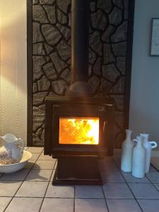 un poêle à bois avec un feu dans une pièce dans l'établissement Little Longbow Lakefront Chalet, à Becket