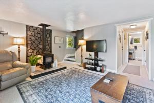 un salon avec un canapé et une cheminée dans l'établissement Little Longbow Lakefront Chalet, à Becket