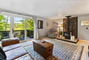 un salon avec un canapé et une cheminée dans l'établissement Little Longbow Lakefront Chalet, à Becket