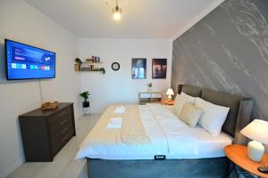 a bedroom with a large bed with a tv on the wall at FLH - Moonwalk in Sibiu