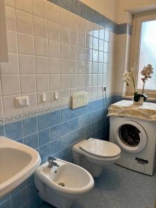 bagno con servizi igienici, lavandino e lavatrice di La Rocchetta Sunset Apartment a Briatico