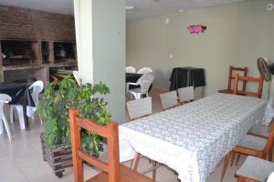 a dining room with a white table and chairs at Los Manantiales in Villa Gesell +34 photos