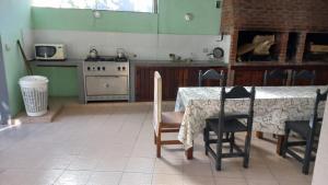 a kitchen with a table with chairs and a stove at Los Manantiales in Villa Gesell