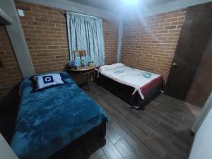 a bedroom with two beds in a brick wall at departamento 2 en condominio in Amecameca de Juárez