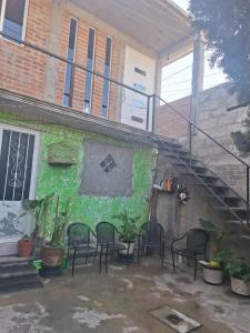 a patio with chairs and a staircase next to a building at departamento 2 en condominio in Amecameca de Juárez