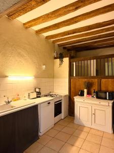 a kitchen with white cabinets and a stove top oven at Aux Ecuries du Signe in Amboise