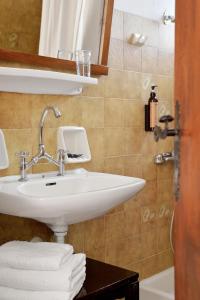 ein Badezimmer mit weißem Waschbecken und Dusche in der Unterkunft Vagia Traditional, Aegina Island in Vaia + 113 Fotos