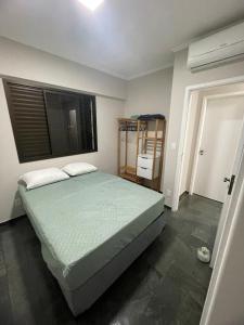 a bedroom with a bed and a window at Apto pe na areia 3 dorm ar cond in Caraguatatuba +23 photos