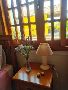 un jarrón de flores sobre una mesa con una lámpara en Refúgios SUNSET Serra Fluminense, en Areal 72 fotos más