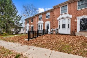 ein Backsteinhaus mit Zaun und einem Laubhaufen in der Unterkunft Modern 3BR • Near Ripken, Bush River & Parks in Joppatowne