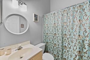 ein Badezimmer mit Waschbecken und Duschvorhang in der Unterkunft Modern 3BR • Near Ripken, Bush River & Parks in Joppatowne + 23 Fotos