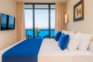 PANORAMA sea VIEW suite APARTMENTS في باتومي: غرفة نوم مع سرير مطل على المحيط