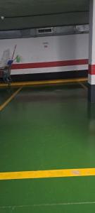 an empty gymnasium with a green floor and avertisement at Hola La Fuente in Puerto de Mogán