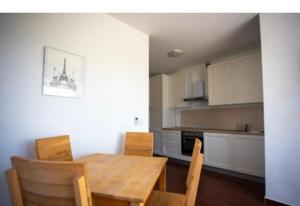 een keuken met een houten tafel en stoelen in een kamer bij Lucia&Laura in Turanj +17 foto's