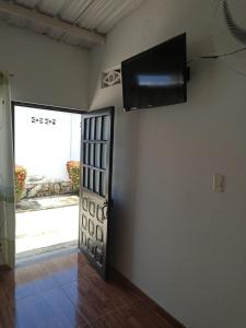 Centro Vacacional Los Pijaos في كارمن دي أبيكالا: غرفة مع باب وتلفزيون على الحائط