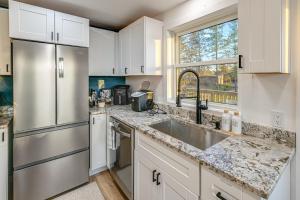 una cucina con mobili bianchi e un frigorifero in acciaio inossidabile di Riverfront Reset! Dells Cabin with Kayaks and Deck a Plainville