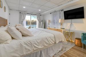 una camera con un grande letto bianco e una TV a schermo piatto di Riverfront Reset! Dells Cabin with Kayaks and Deck a Plainville