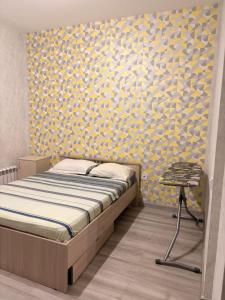 Apple city في Prigorodnyy: غرفة نوم بسرير وجدار اصفر