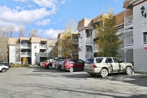 Un estacionamiento con autos estacionados frente a los edificios. en Tannhauser 121, en Breckenridge