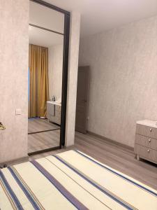 Apple city في Prigorodnyy: حمام مع مرآة ومغسلة