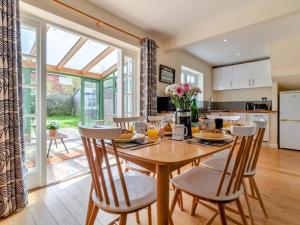 a kitchen and dining room with a wooden table and chairs at 3 Bed in Brancaster Staithe oc-kt150 in Brancaster