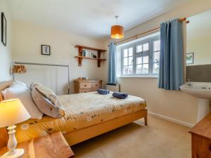 a bedroom with a bed and a sink and a window at 3 Bed in Brancaster Staithe oc-kt150 in Brancaster