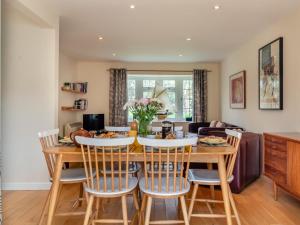 a kitchen and living room with a wooden table and chairs at 3 Bed in Brancaster Staithe oc-kt150 in Brancaster