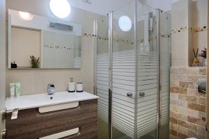 a bathroom with a glass shower and a sink at Melony Tsfat in Safed