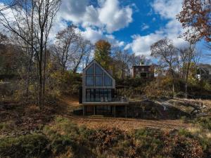 a house sitting on a bench in the woods at Shatemuc, a magical getaway on the Hudson River in Kingston