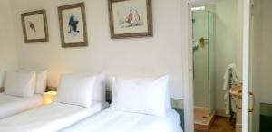 a bedroom with two beds and two pictures on the wall at The Osprey Hotel in Kingussie +17 photos