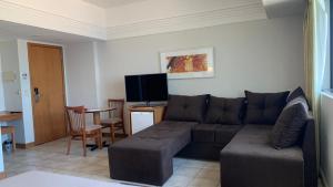 a living room with a couch and a flat screen tv at Flat Vista Pôr do Sol in Manaus