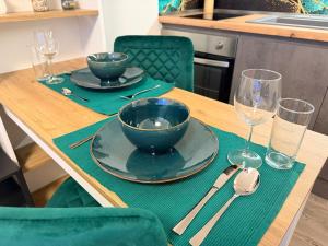 a wooden table with two plates and wine glasses at SkyView Studio Vlčince with private parking in Žilina