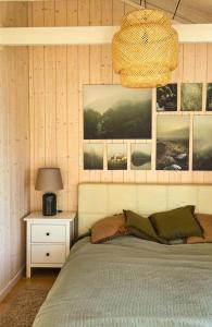 ein Schlafzimmer mit einem Bett, einer Lampe und Bildern an der Wand in der Unterkunft Harnas in Säffle