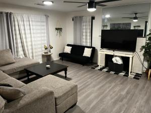 a living room with a couch and a tv and a fireplace at Urban Estates - Peak Haven - Stay Explore Belong in Flagstaff