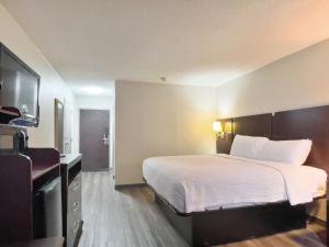 a hotel room with a bed and a flat screen tv at Havelock Hotel in Havelock