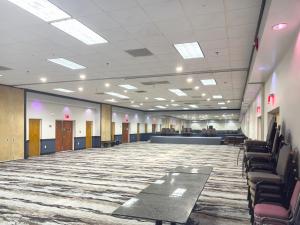 a large room with chairs and a carpeted floor at Havelock Hotel in Havelock +3 photos