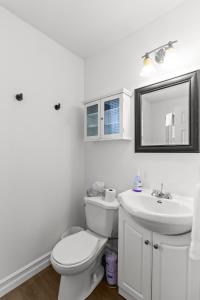 a white bathroom with a toilet and a sink at Relaxing 2BR Parking Self Check-In in Torbay +7 photos