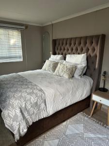 a bedroom with a large bed with a large headboard at Royaltics place in Weltevredenpark +5 photos