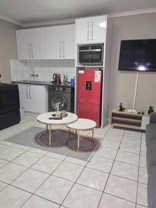 a kitchen with a table and a red refrigerator at Royaltics place in Weltevredenpark