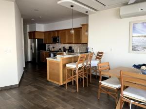 una cucina con mobili in legno, tavolo e sedie di VIVO 2 Bedroom Ocean Front Condo 180 degree ocean views a Puerto Escondido